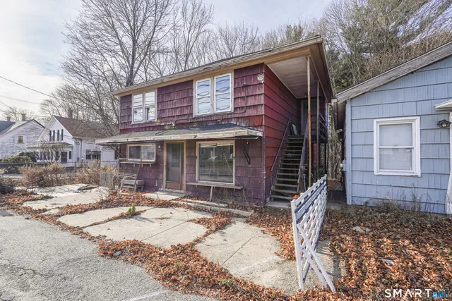 a front view of a house with a yard covered with snow in front of house