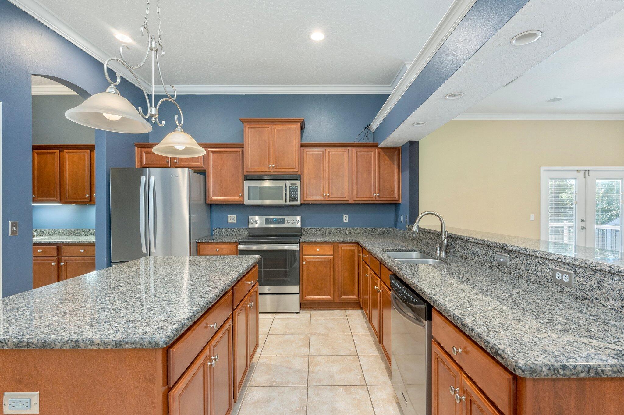 203 Eleases Crossing Crestview, FL 32539 - Photo 11 of 35 a kitchen with stainless steel appliances granite countertop a sink a stove and a wooden cabinets