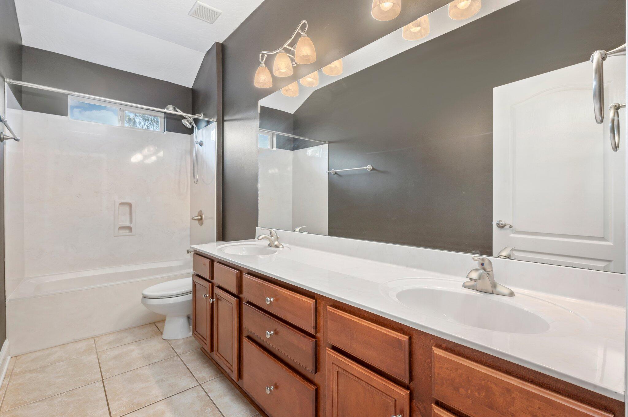 203 Eleases Crossing Crestview, FL 32539 - Photo 28 of 35 a bathroom with a double vanity sink toilet mirror and bathtub