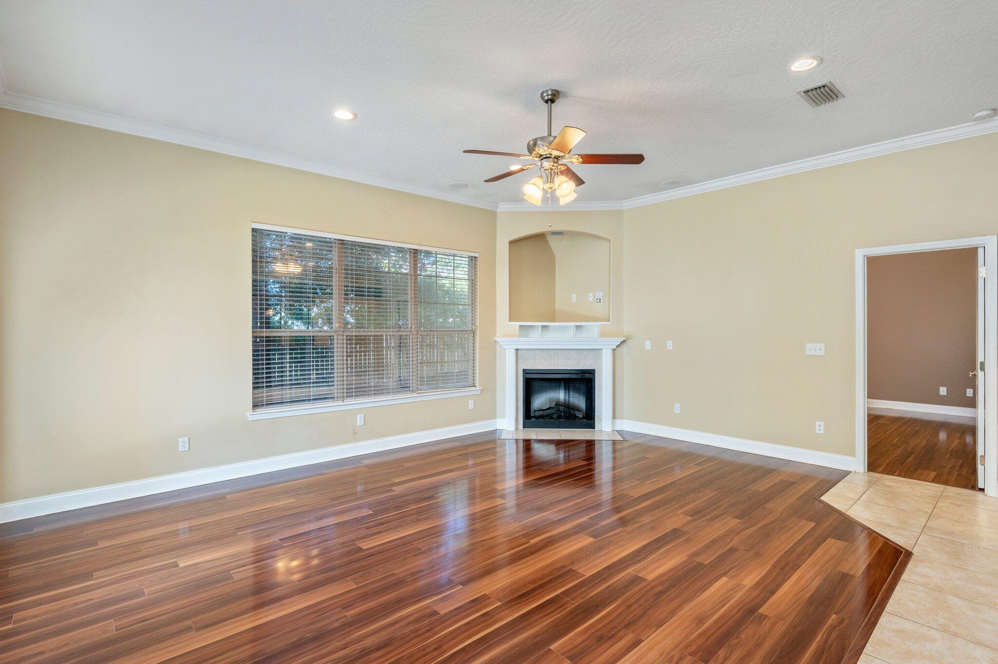 203 Eleases Crossing Crestview, FL 32539 - Photo 6 of 35 an empty room with wooden floor fireplace and windows