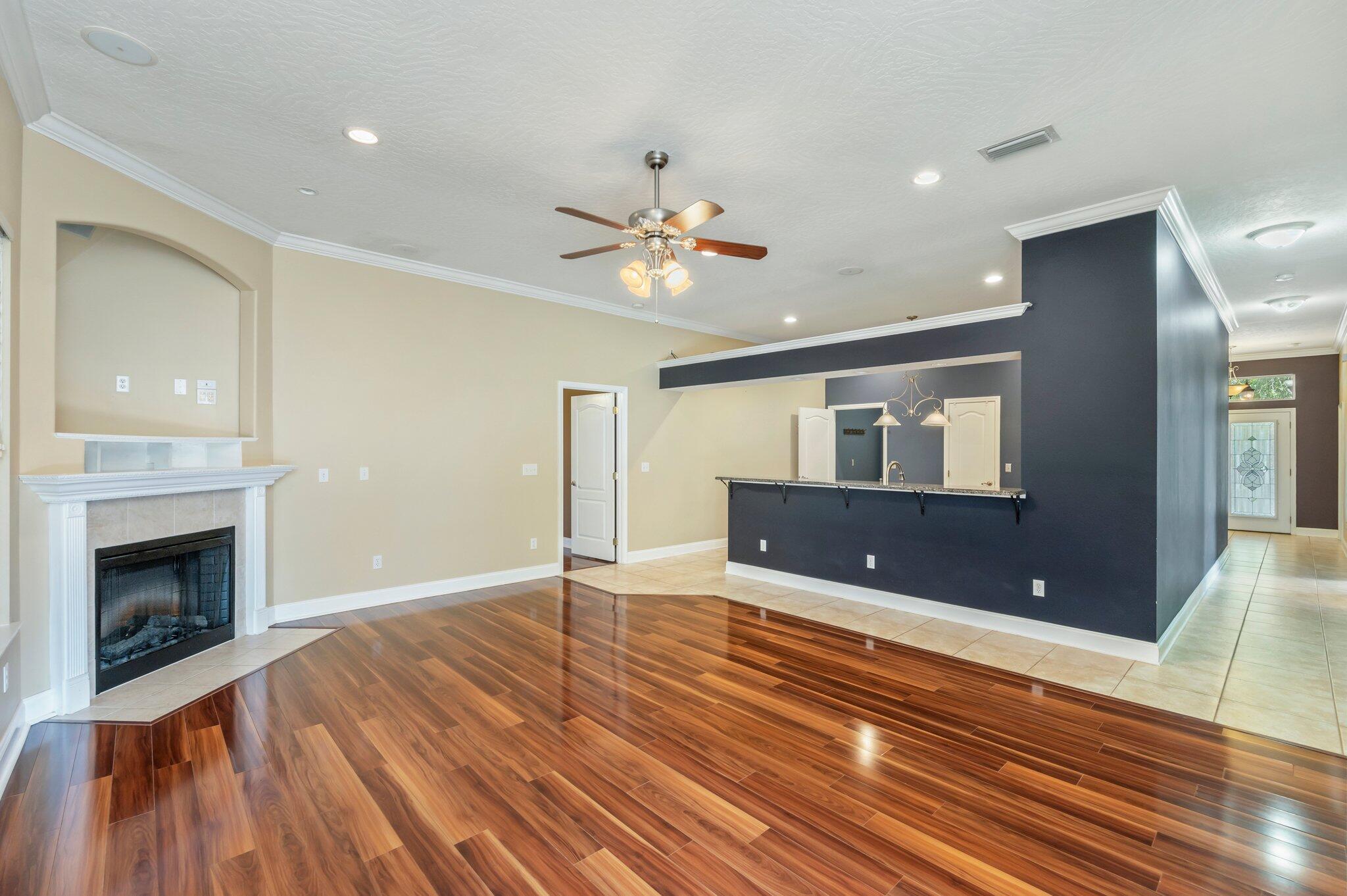 203 Eleases Crossing Crestview, FL 32539 - Photo 7 of 35 a view of an empty room with wooden floor fireplace and a window