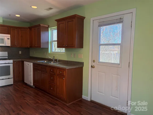 a kitchen with granite countertop wooden cabinets and white appliances