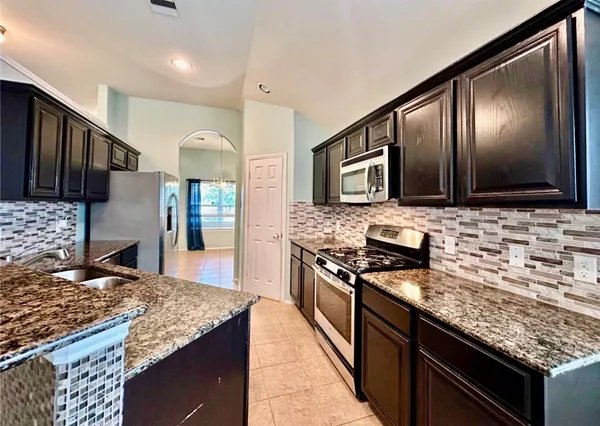 a kitchen with stainless steel appliances granite countertop a sink stove and oven