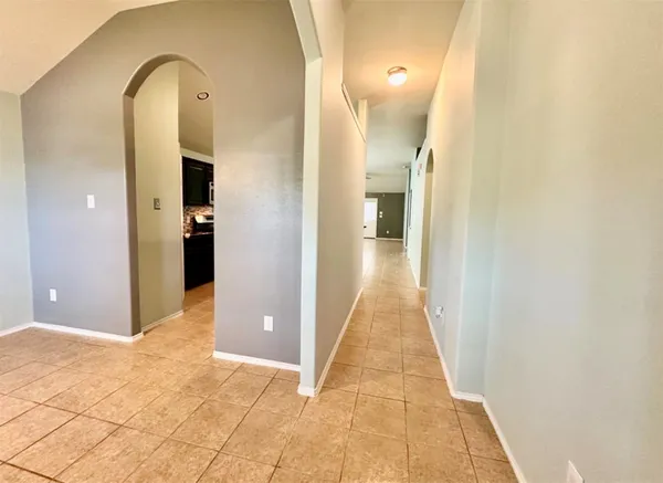 a view of a hallway with wooden floor and a bathroom