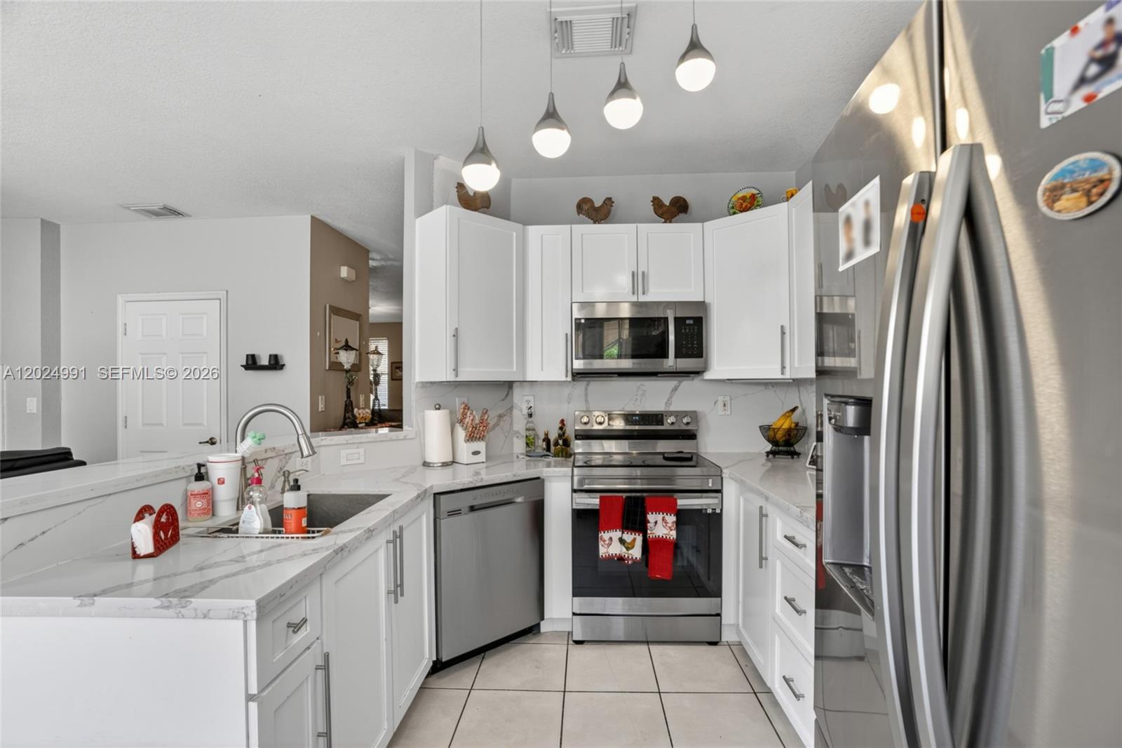16651 Southwest 79th Terrace Miami, FL 33193 - Photo 16 of 34 a kitchen with a sink stainless steel appliances and white cabinets