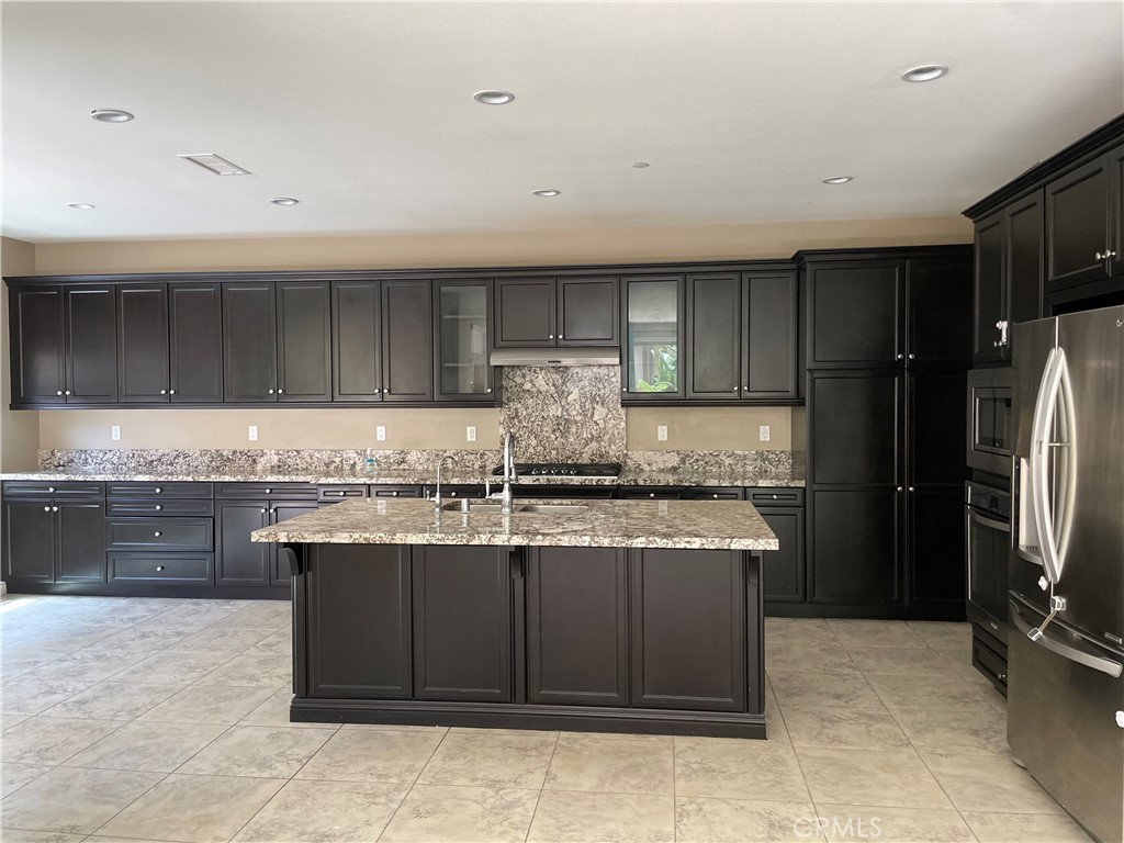 a kitchen with stainless steel appliances granite countertop a stove a refrigerator and a sink