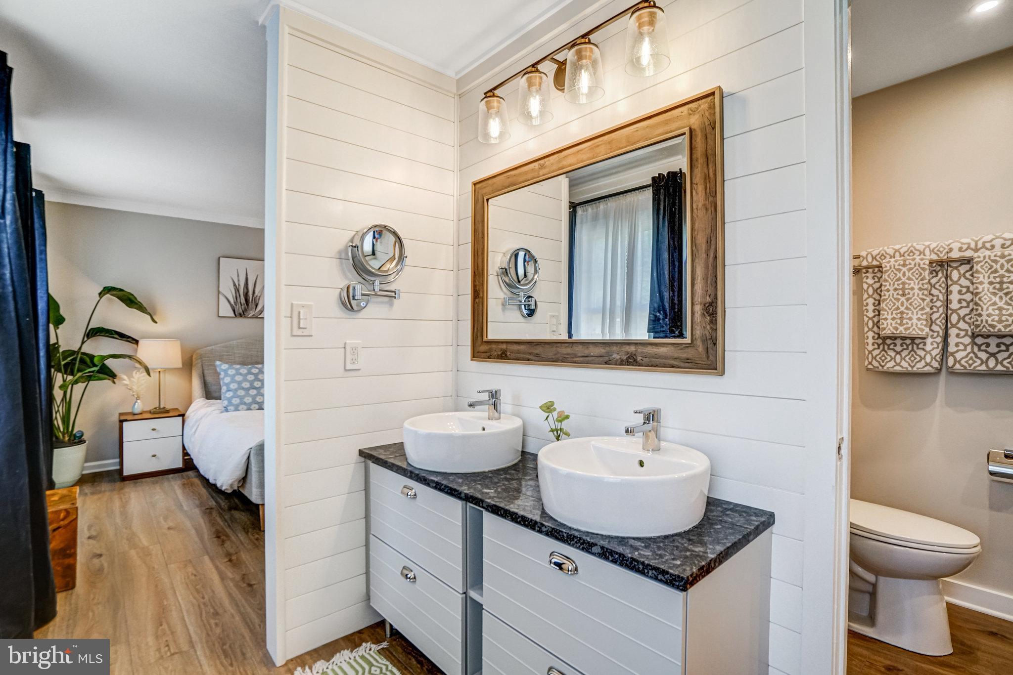 7923 Forest Path Way Springfield, VA 22153 - Photo 19 of 39 a bathroom with a granite countertop sink a toilet and mirror