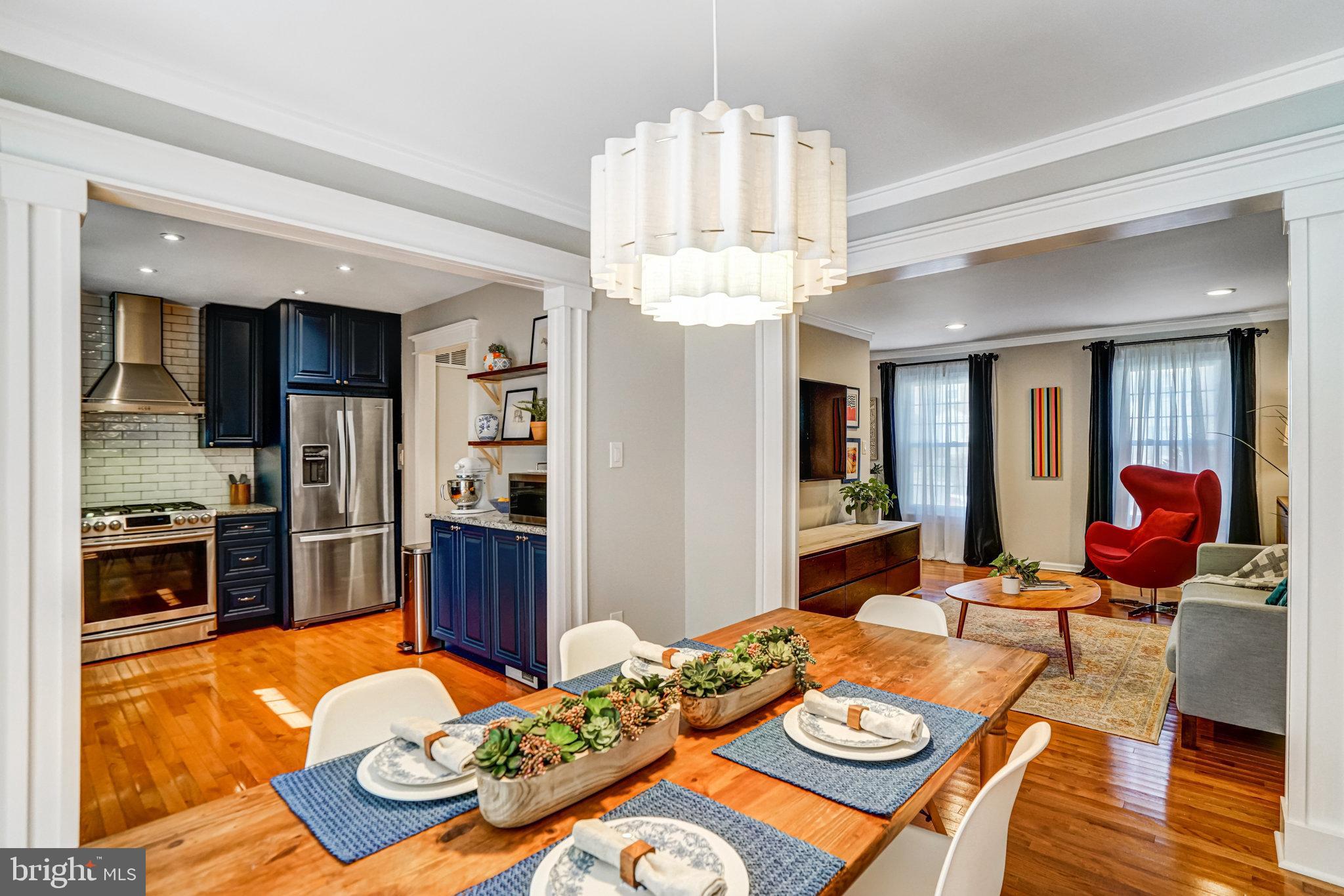 7923 Forest Path Way Springfield, VA 22153 - Photo 9 of 39 a dining room with wooden floor a chandelier a wooden table and chairs
