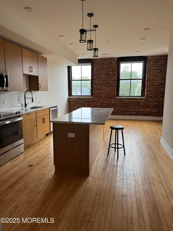 a kitchen with stainless steel appliances granite countertop wooden floors and sink