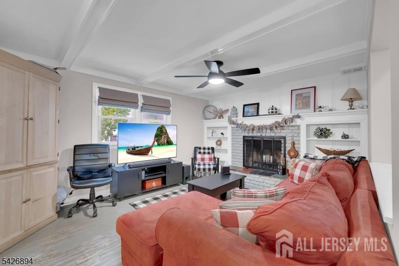 233 Maple Avenue Dunellen, NJ 08812 - Photo 13 of 39 a living room with furniture a fireplace and a flat screen tv