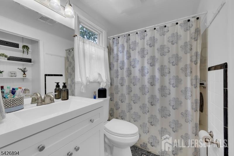 233 Maple Avenue Dunellen, NJ 08812 - Photo 26 of 39 a bathroom with a sink a toilet and a mirror