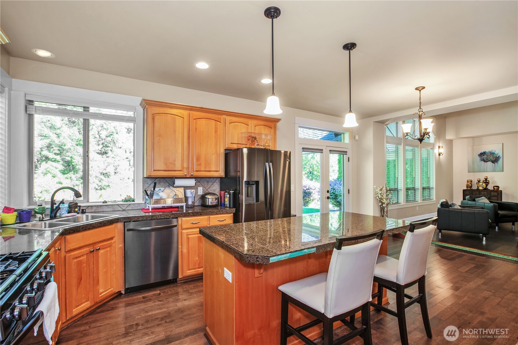 3930 Cameron Drive Northeast Lacey, WA 98516 - Photo 13 of 40 a kitchen with stainless steel appliances granite countertop a stove top oven a sink dishwasher a dining table and chairs with wooden floor