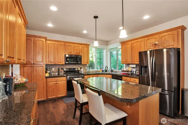 a kitchen with stainless steel appliances granite countertop a sink refrigerator and microwave