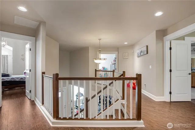 a view of a hallway with wooden floor and stairs