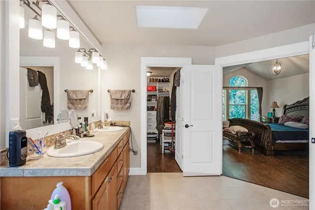 a en suite bathroom with a double vanity sink and a mirror