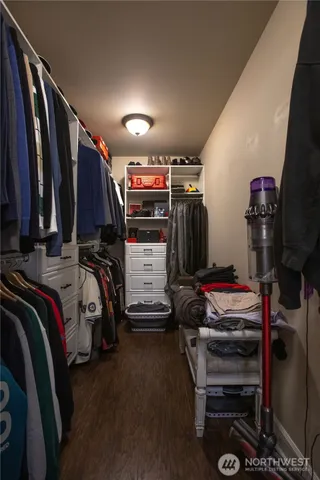 a view of walk in closet with clothes and shoes