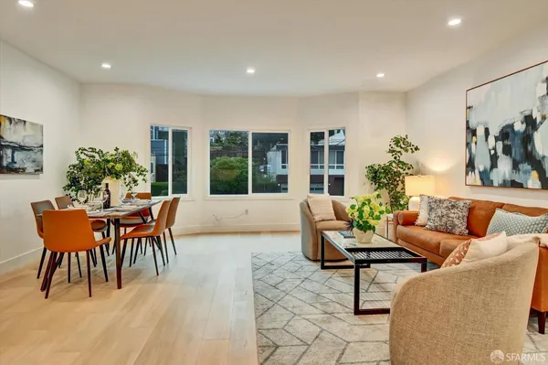 a living room with furniture a window and a potted plant