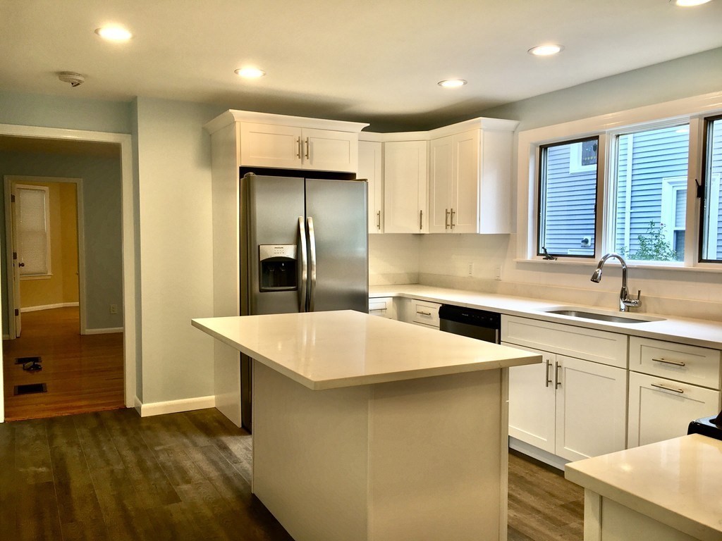 31 Wellington Road Medford, MA 02155 - Photo 1 of 11 a kitchen with a sink a refrigerator and white cabinets