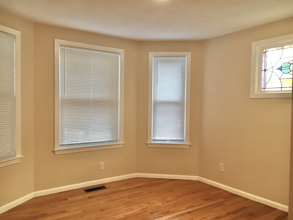 31 Wellington Road Medford, MA 02155 - Photo 5 of 11 a view of an empty room with wooden floor and a window