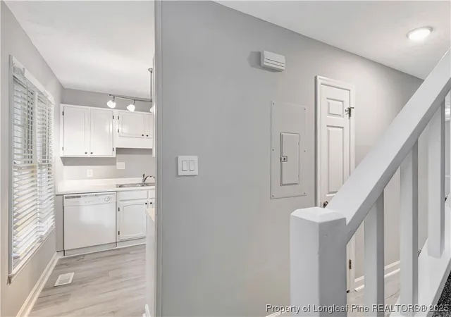 a room with white cabinets and a sink
