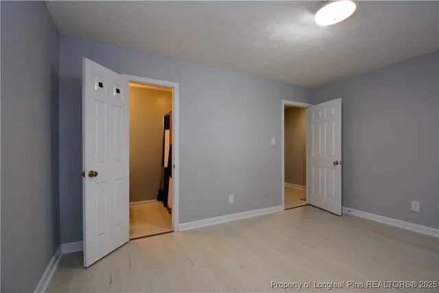 an empty room with closet and mirror