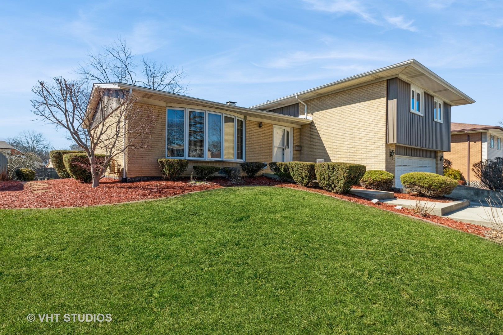 a front view of a house with a yard and trees