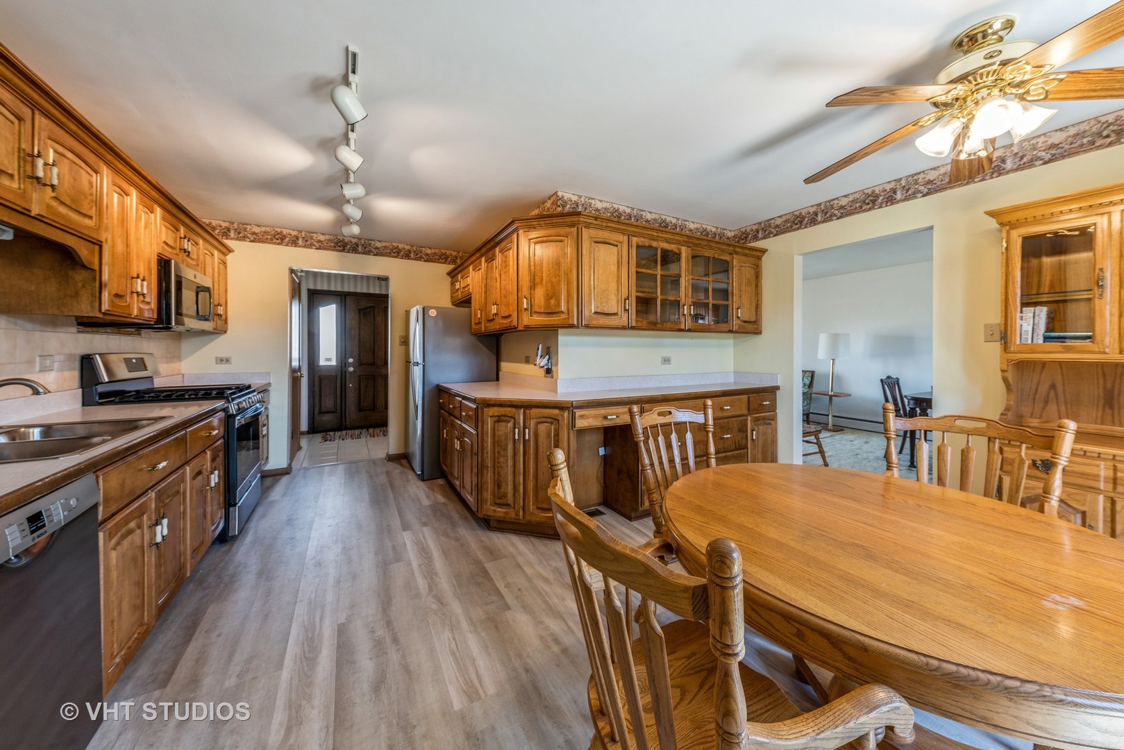 15416 Pine Drive Oak Forest, IL 60452 - Photo 5 of 12 a kitchen with stainless steel appliances granite countertop a stove a sink dishwasher a dining table and chairs with wooden floor