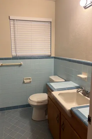 a bathroom with a sink a toilet and a window