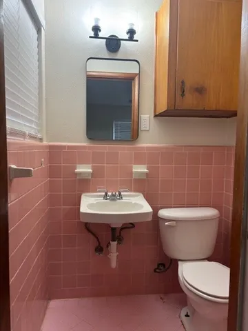a bathroom with a toilet a sink and mirror