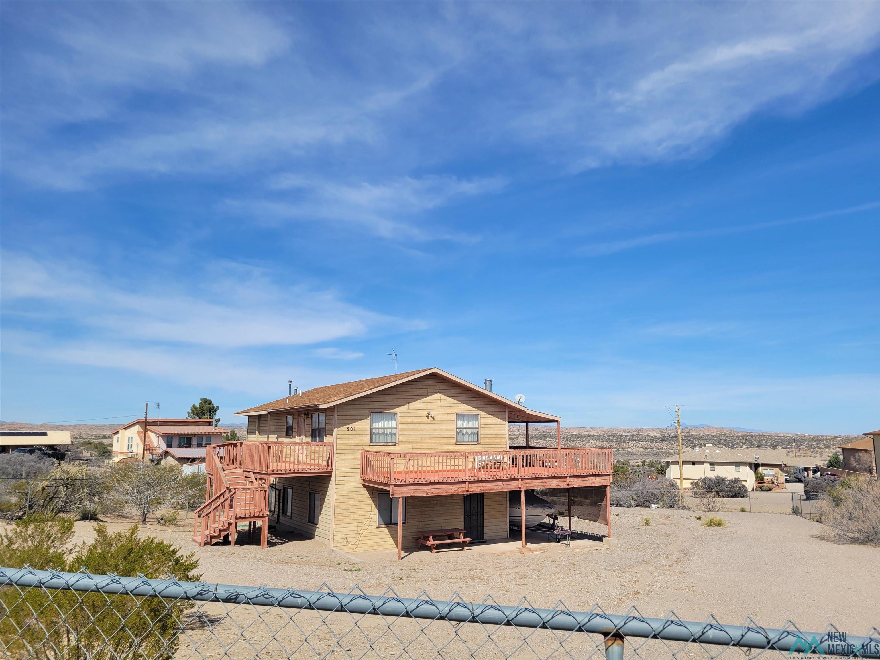 501 Springland Boulevard Elephant Butte, NM 87935 - Photo 28 of 38 Two-story residence featuring light-colored siding and a brown shingle roof