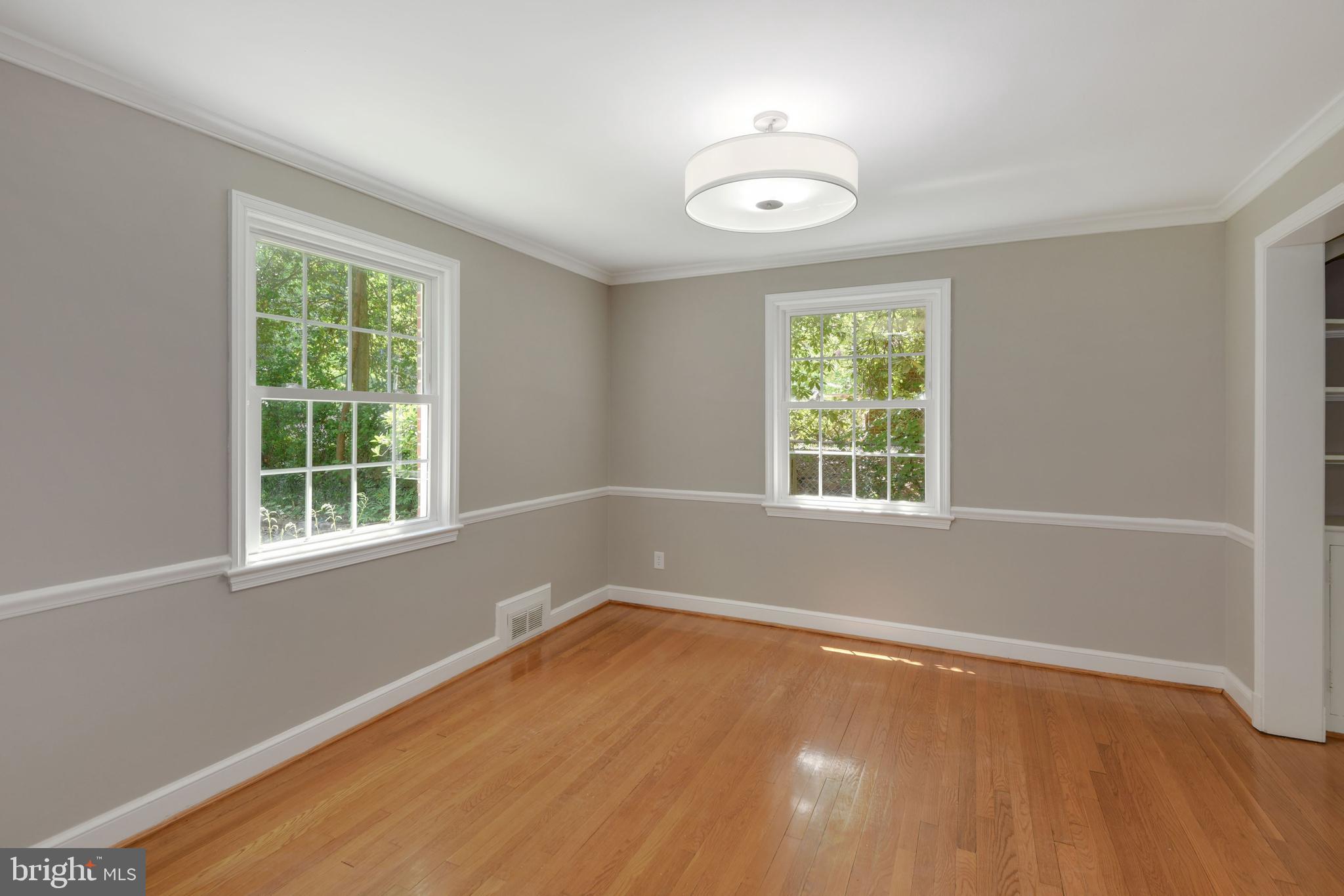 7215 Rollingwood Drive Chevy Chase, MD 20815 - Photo 11 of 42 a view of an empty room with wooden floor and a window