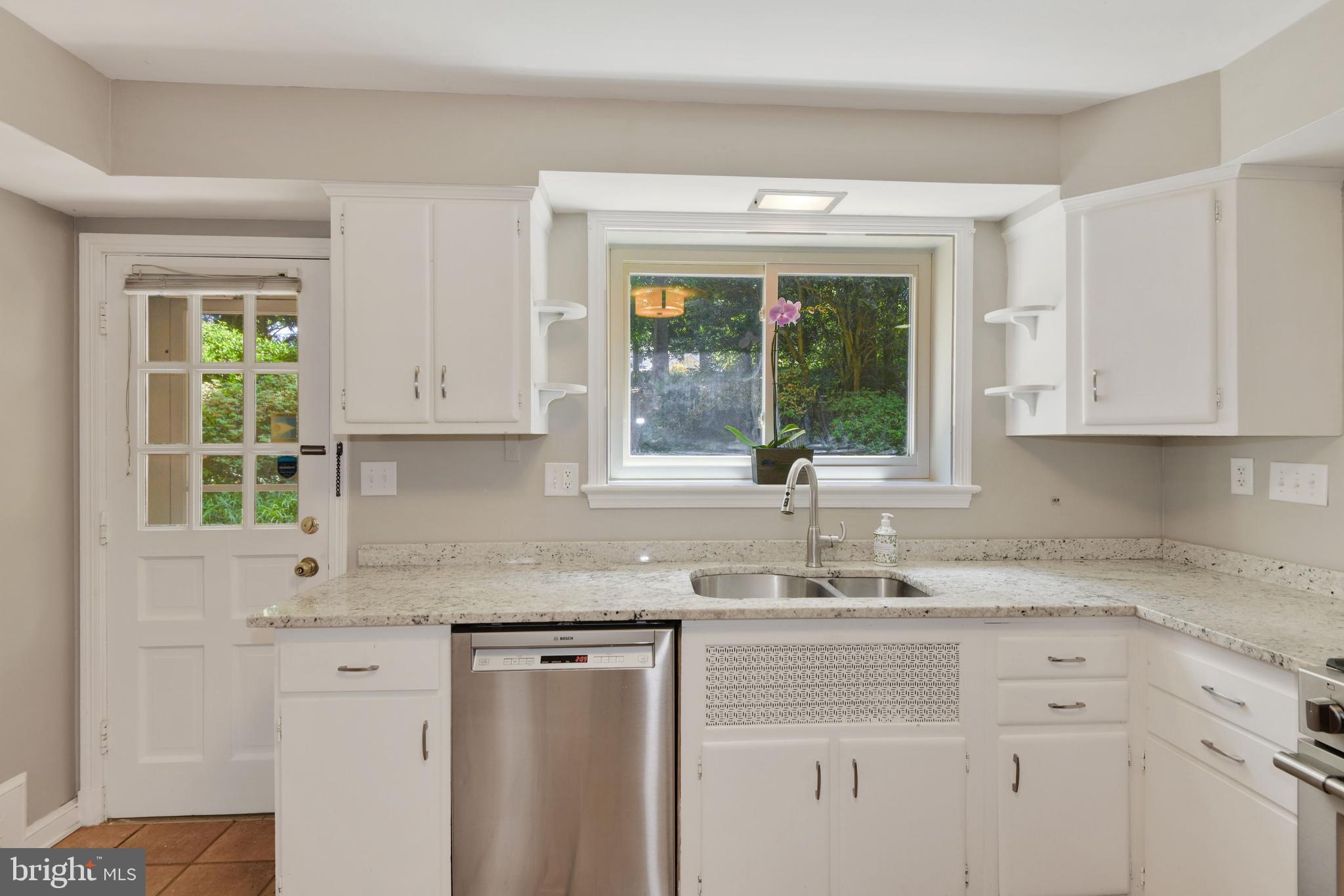 7215 Rollingwood Drive Chevy Chase, MD 20815 - Photo 13 of 42 a kitchen with granite countertop white cabinets white appliances and a sink