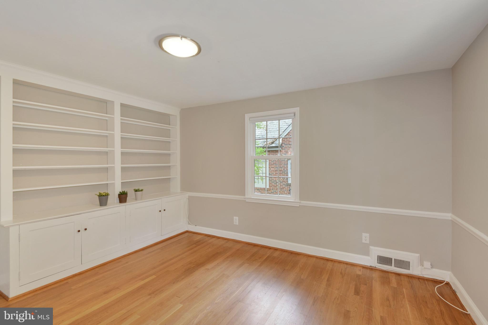 7215 Rollingwood Drive Chevy Chase, MD 20815 - Photo 16 of 42 a view of an empty room with a window and wooden floor