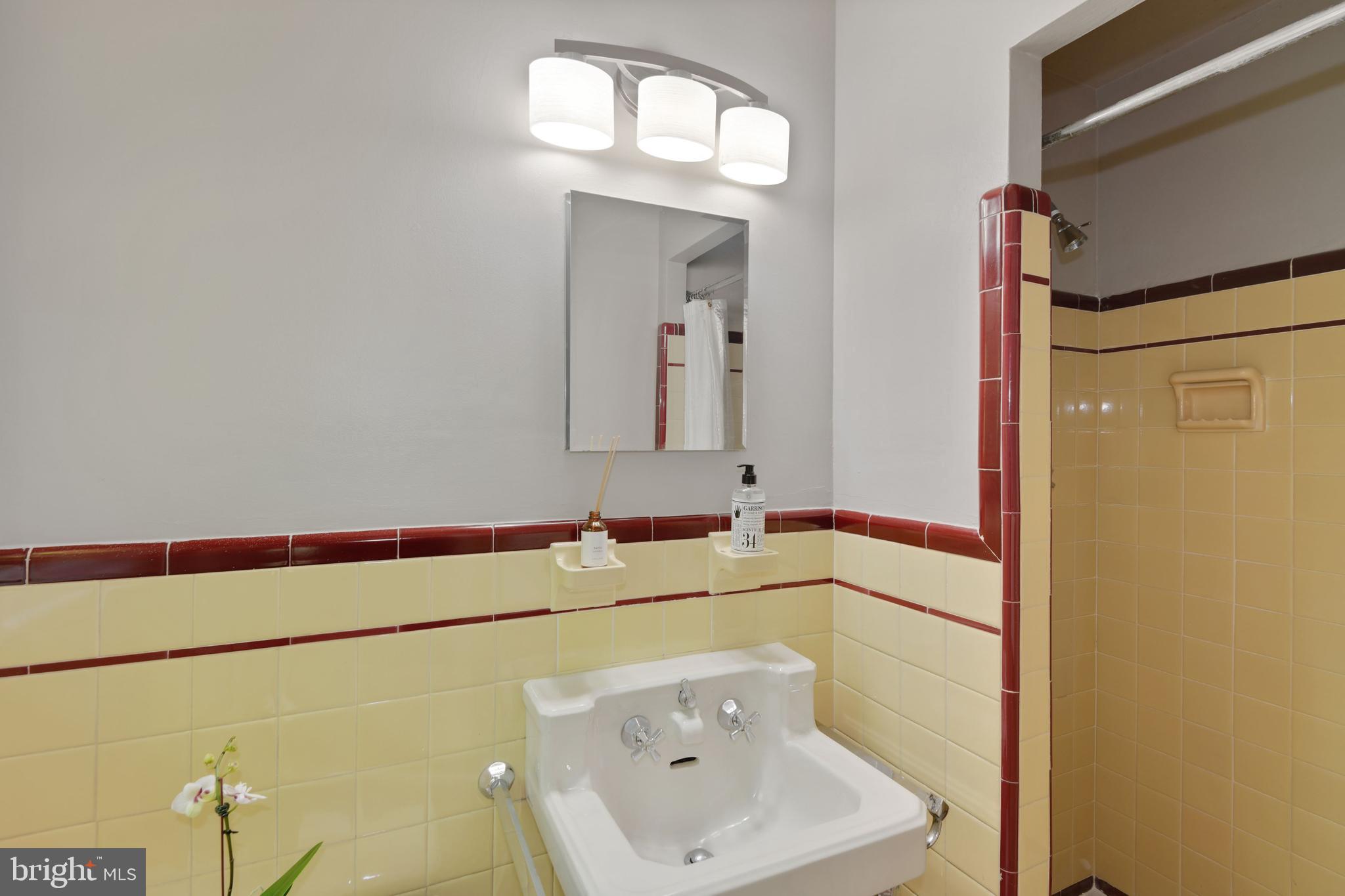 7215 Rollingwood Drive Chevy Chase, MD 20815 - Photo 18 of 42 a bathroom with a sink and a mirror