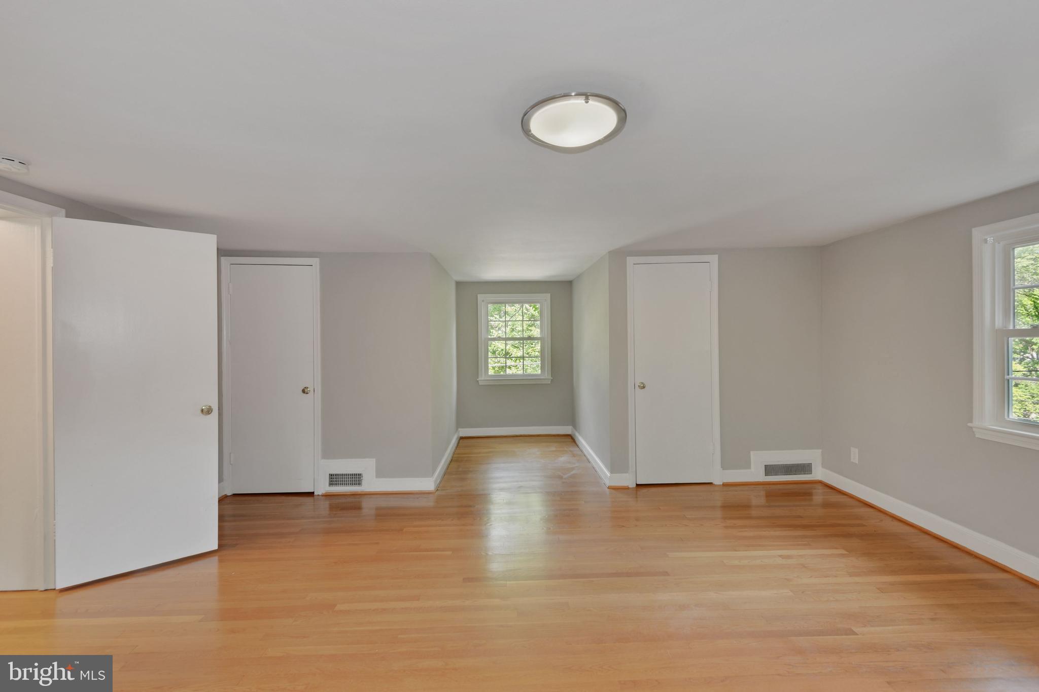 7215 Rollingwood Drive Chevy Chase, MD 20815 - Photo 22 of 42 a view of an empty room with wooden floor and a window