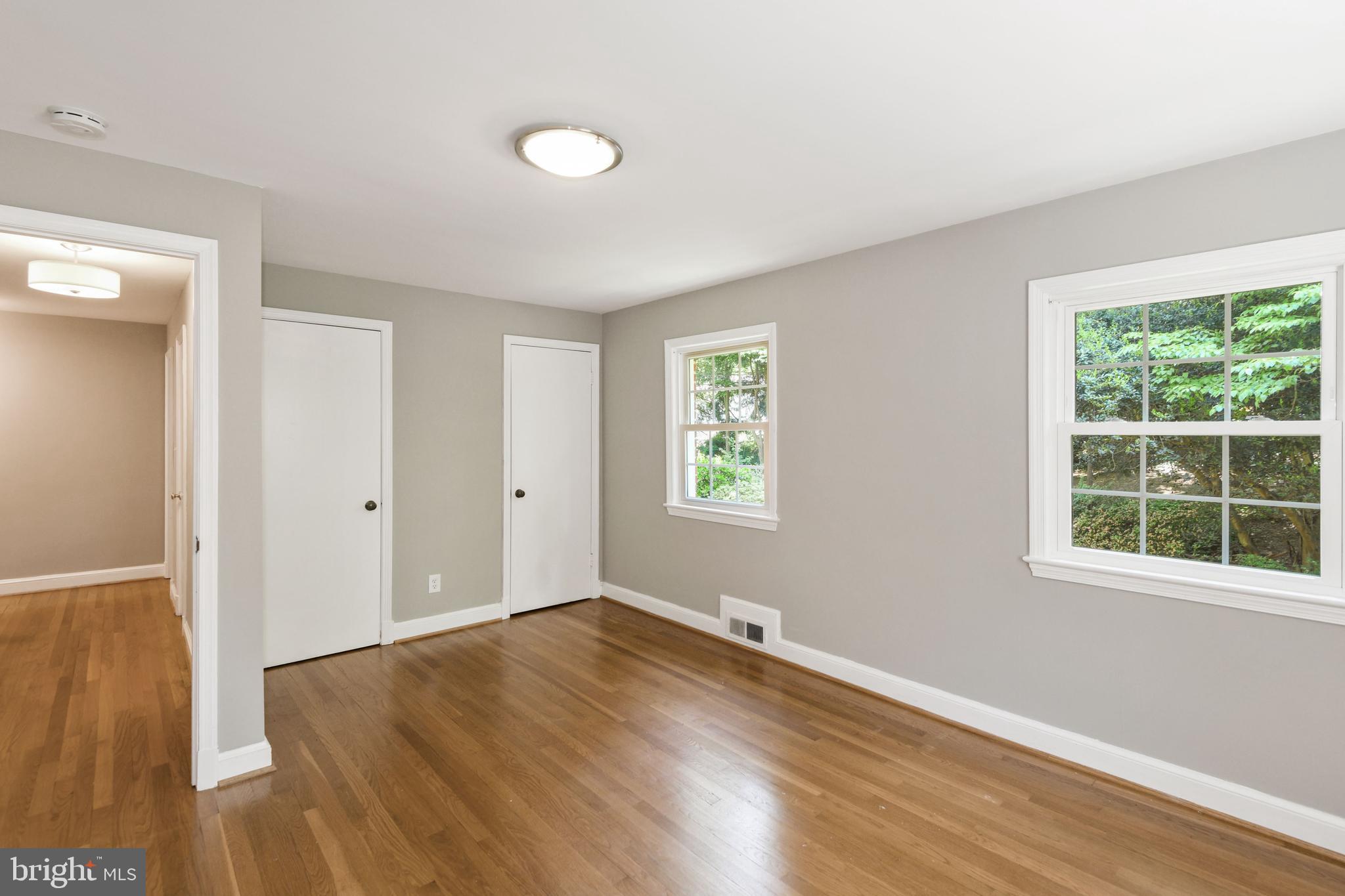 7215 Rollingwood Drive Chevy Chase, MD 20815 - Photo 26 of 42 an empty room with wooden floor and windows