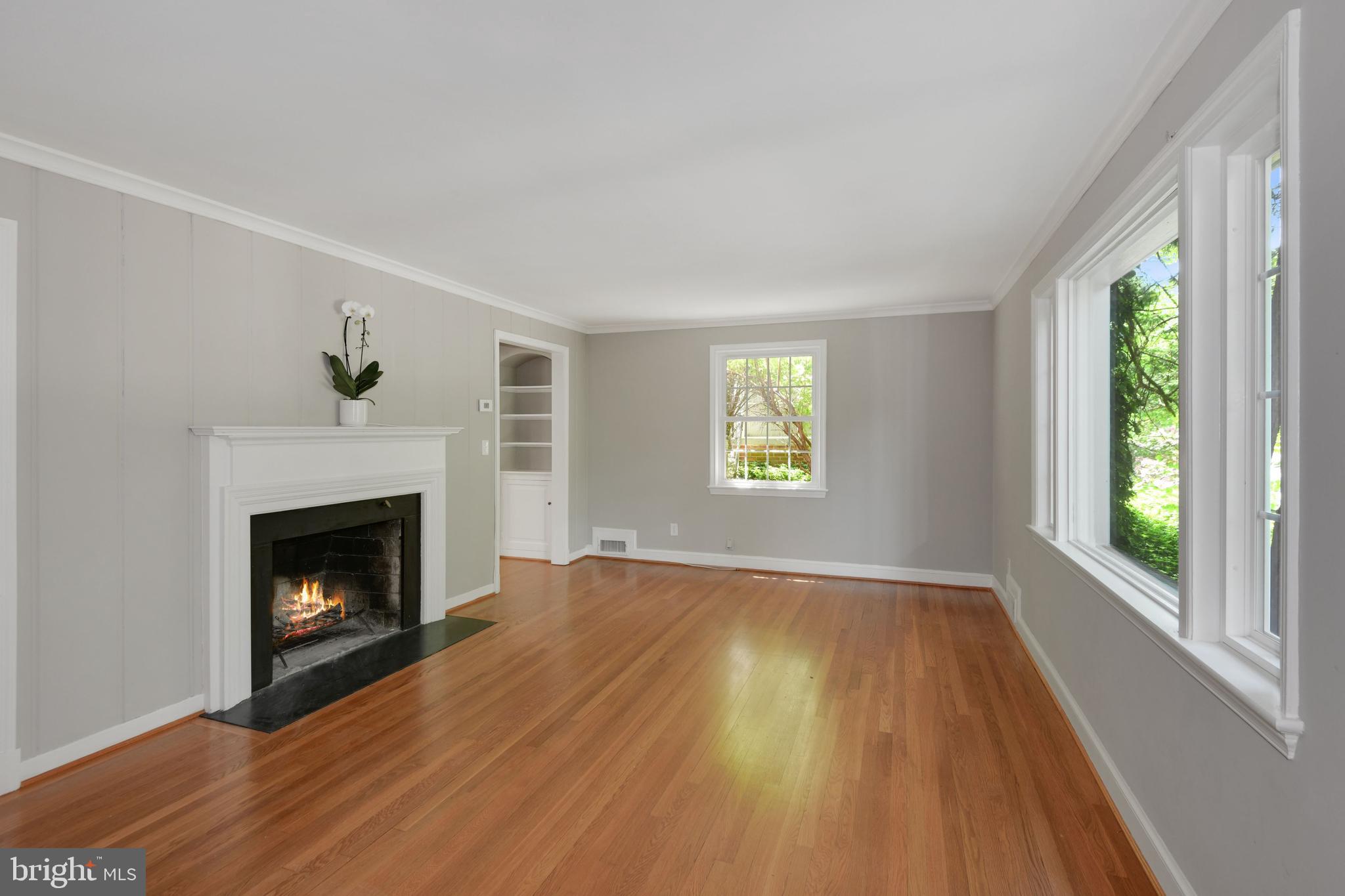7215 Rollingwood Drive Chevy Chase, MD 20815 - Photo 6 of 42 a view of an empty room with wooden floor fireplace and a window