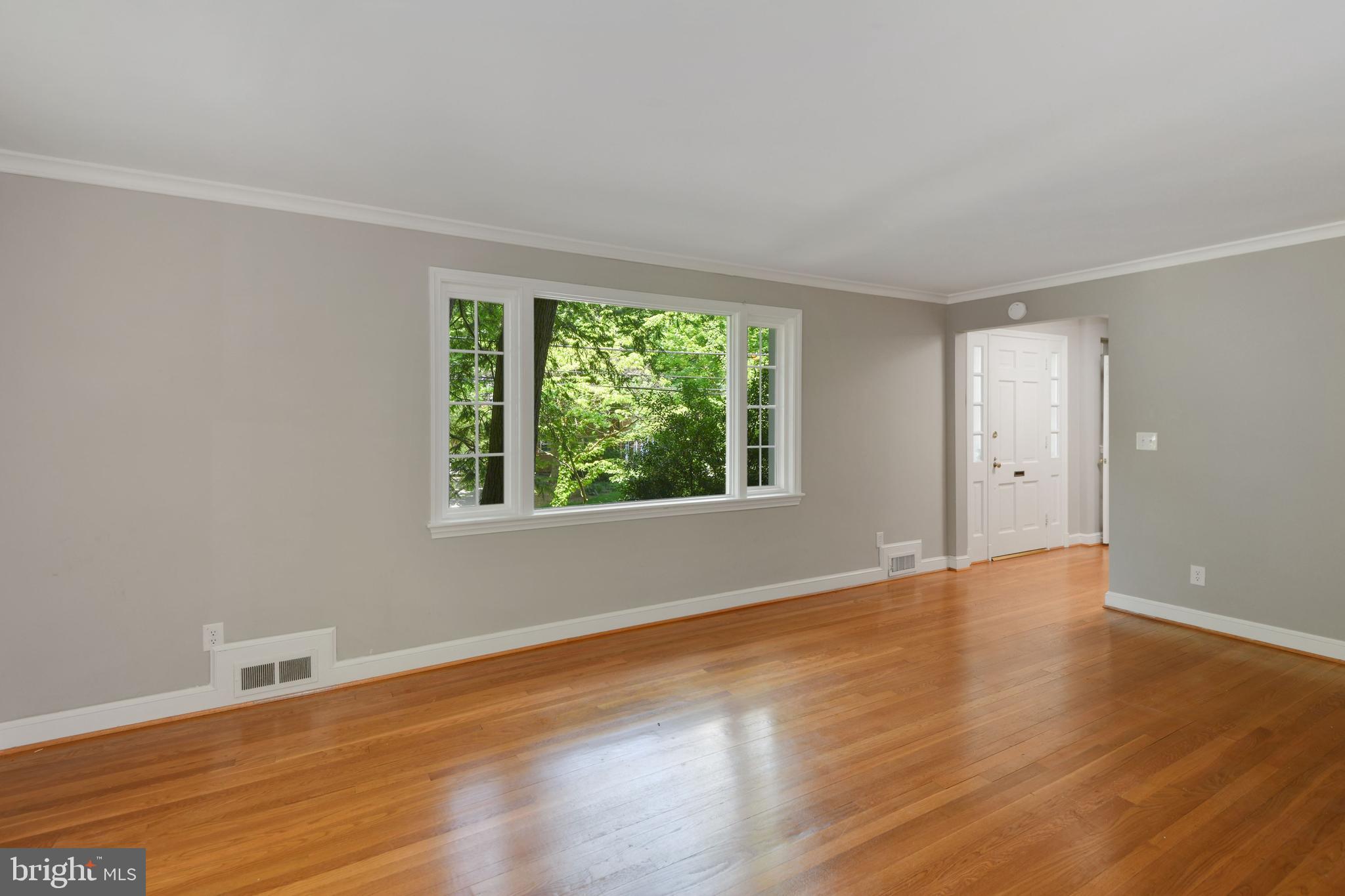 7215 Rollingwood Drive Chevy Chase, MD 20815 - Photo 8 of 42 a view of an empty room with wooden floor and a window