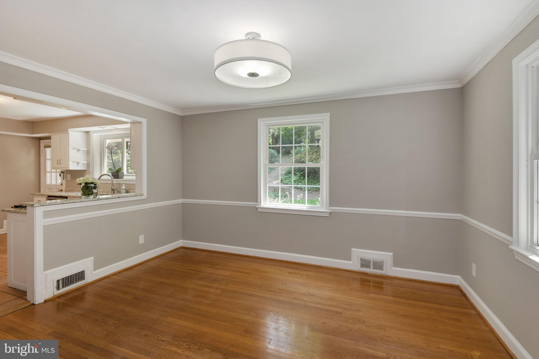 7215 Rollingwood Drive Chevy Chase, MD 20815 - Photo 9 of 42 an empty room with wooden floor and windows