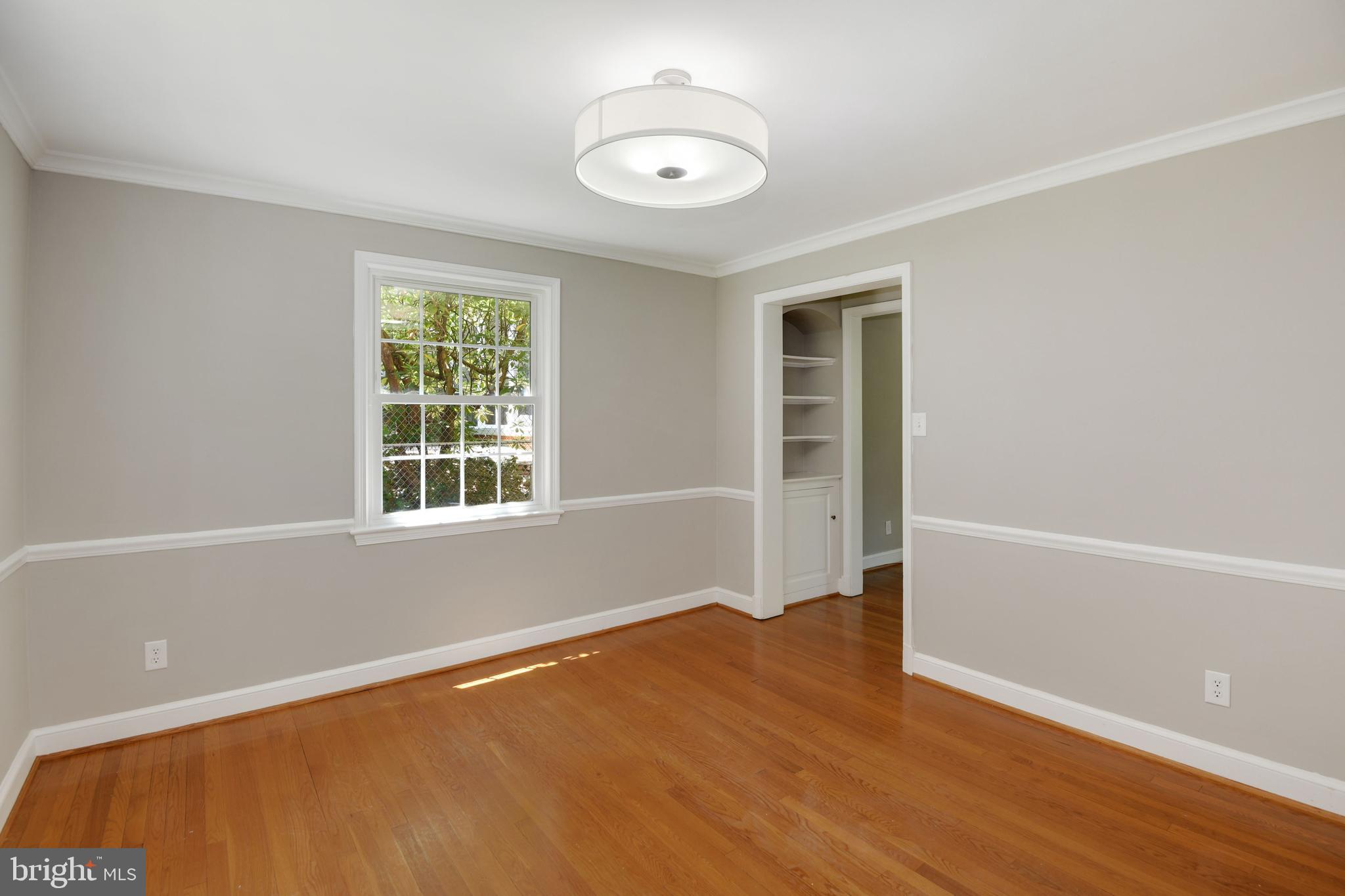 7215 Rollingwood Drive Chevy Chase, MD 20815 - Photo 10 of 42 an empty room with wooden floor and windows