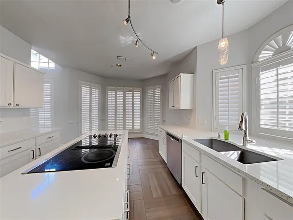 a kitchen with stainless steel appliances a sink a counter space a window and cabinets