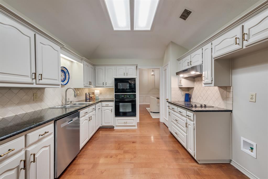 907 Sunpoint Circle Rockwall, TX 75087 - Photo 13 of 37 a large kitchen with stainless steel appliances granite countertop a sink and cabinets