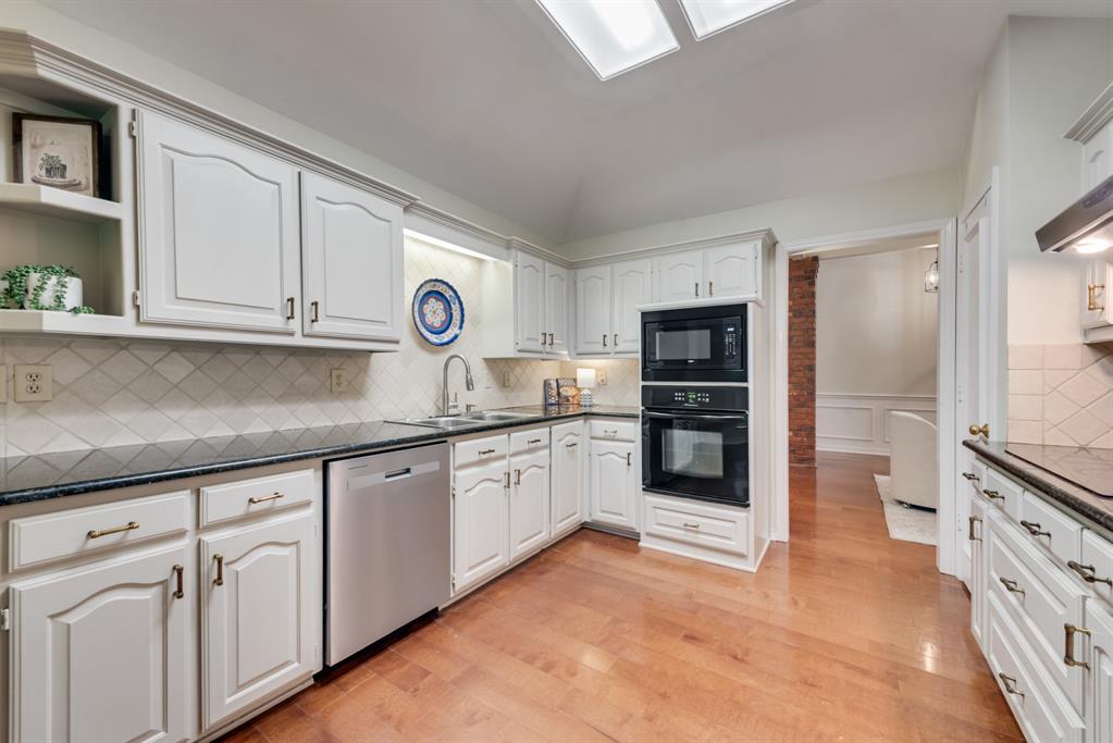 907 Sunpoint Circle Rockwall, TX 75087 - Photo 14 of 37 a kitchen with granite countertop white cabinets and stainless steel appliances