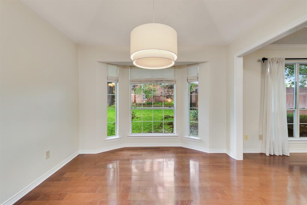 907 Sunpoint Circle Rockwall, TX 75087 - Photo 16 of 37 a view of an empty room with wooden floor and a window