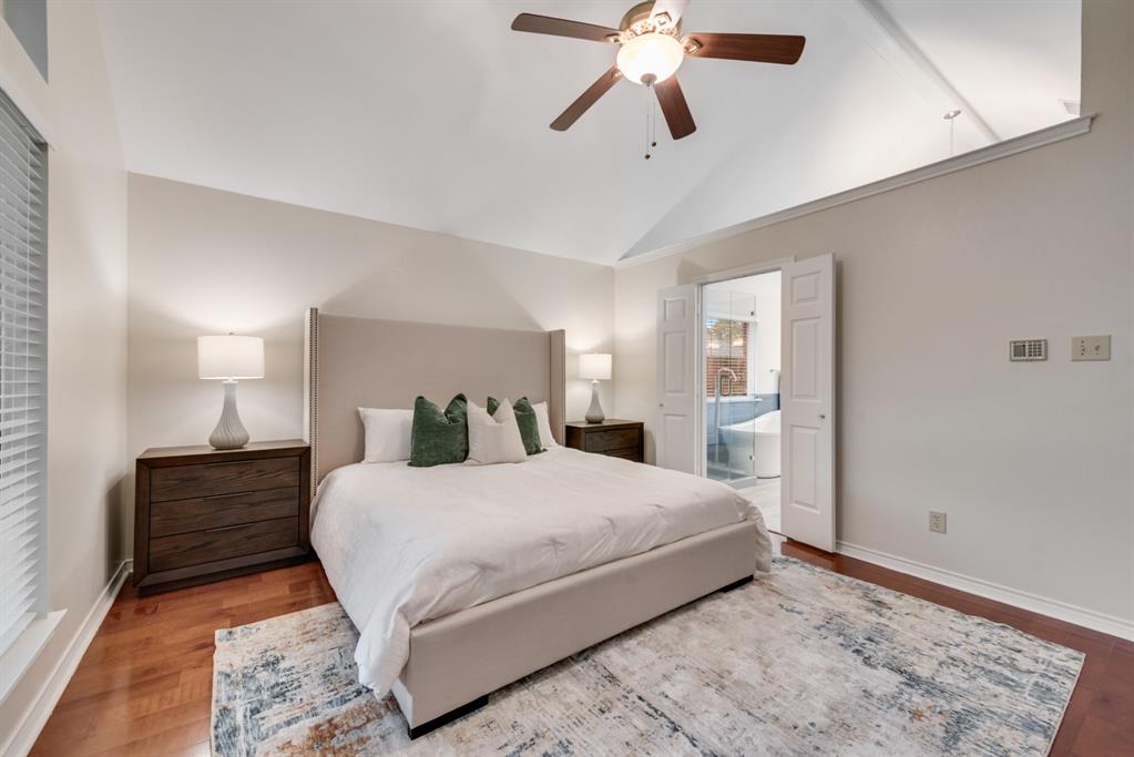 907 Sunpoint Circle Rockwall, TX 75087 - Photo 19 of 37 a bedroom with a large bed and a chandelier