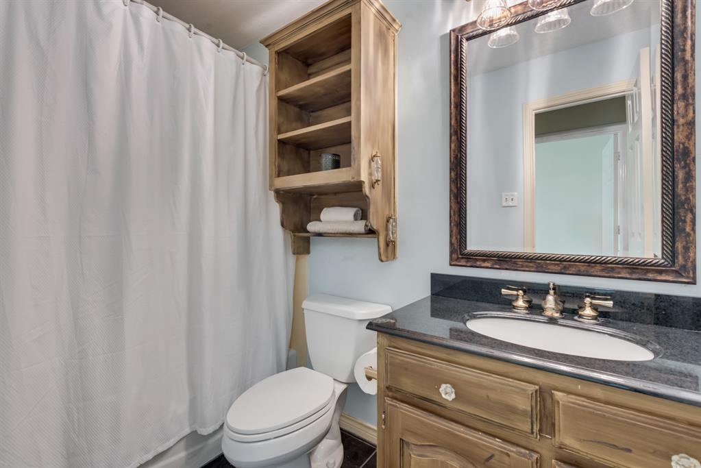 907 Sunpoint Circle Rockwall, TX 75087 - Photo 32 of 37 a bathroom with a granite countertop sink toilet and a mirror