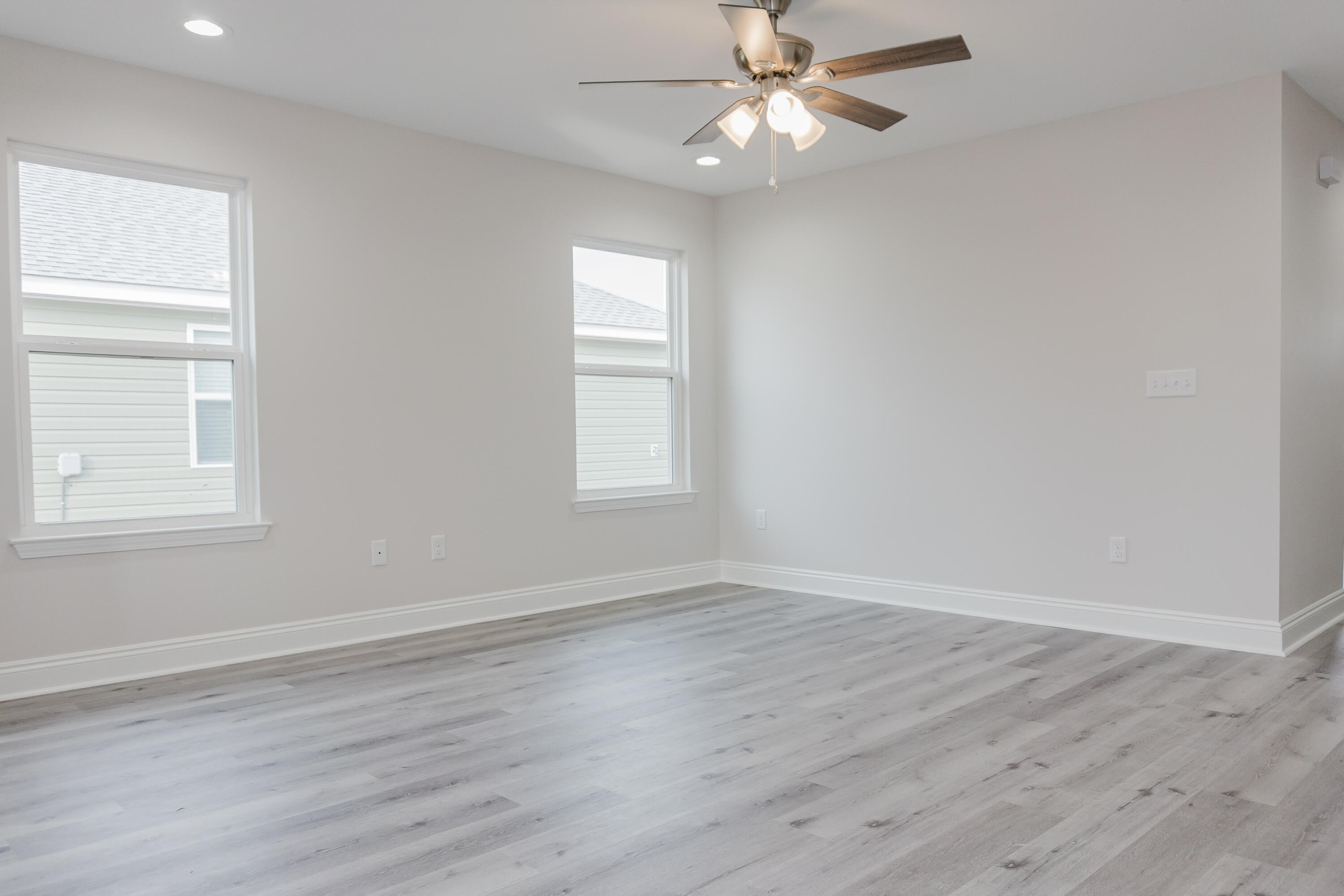 5352 Highview Drive Crestview, FL 32539 - Photo 17 of 32 an empty room with wooden floor fan and windows