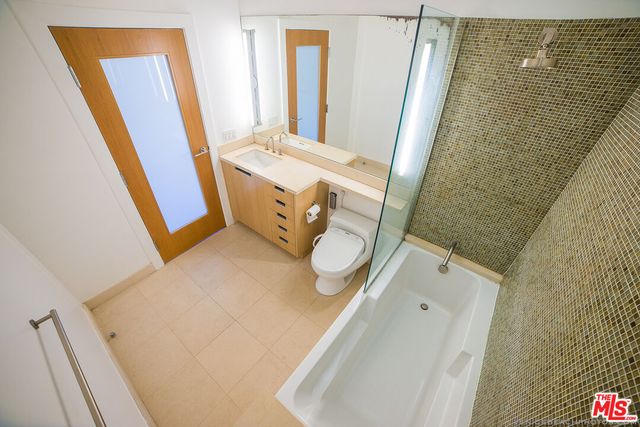 a bathroom with a sink and mirror with bathtub