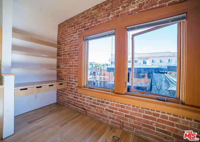 a view of a door and an empty room with wooden floor