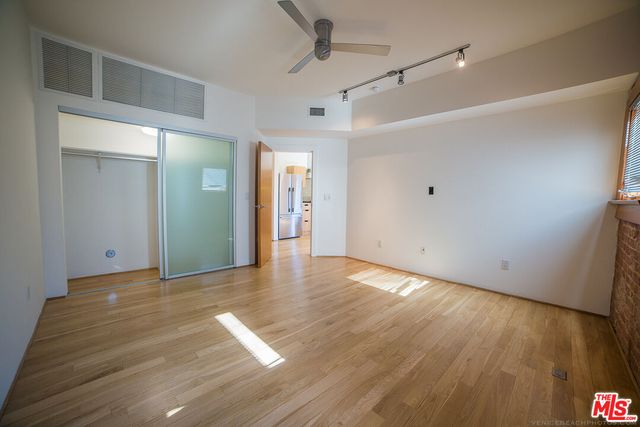 a view of an empty room with wooden floor